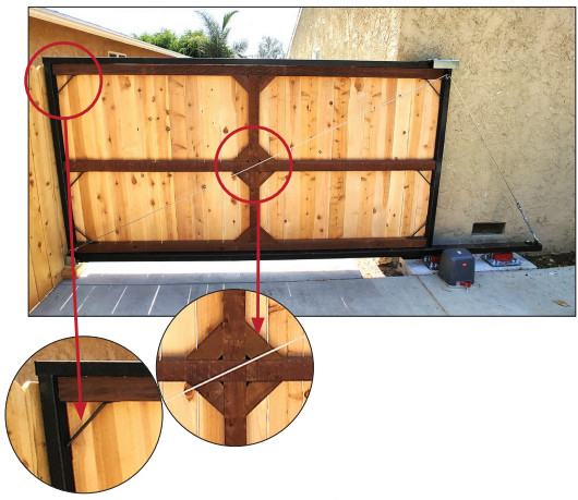 Close-up photo of triangular gussets welded into the corners of a cantilever gate frame next to the vertical uprights